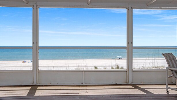 Eine überdachte Terrasse mit Blick auf den Strand.
