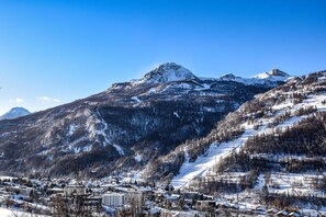 A mountainous landscape with a town in the foreground. - 350m from resort center, Ground floor, terrace, 39m², Serre Chevalier (Saint-Chaffrey)