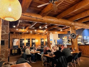 Ein rustikales Interieur mit Holzbalken, Steinwänden und einer Bar.
