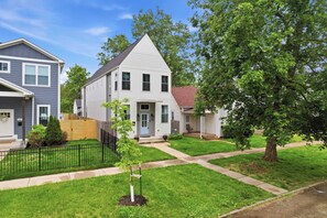A residential area with houses, a well-maintained lawn, and a tree. - Victory Lane Villa | Game Room - Hot Tub - Firepit (Indianapolis)
