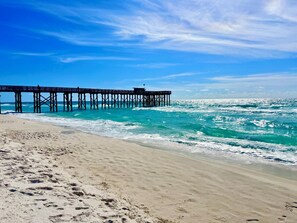 A pier extending into the ocean with a sandy beach in the foreground. - Get A Wave From it All - Panoramic Ocean View (Panama City Beach)