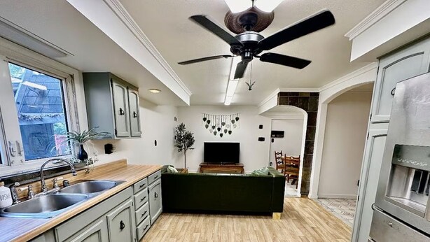 A modern kitchen with a central island, built-in cabinets, a ceiling fan, and a large window. - Cozy Spacious Quiant 2-bed 2-bath apartment. (Wilmington)
