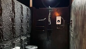 A compact bathroom with a toilet, a sink, a shower, and a wall-mounted heater.