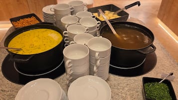 Disposição de buffet com diversos pratos e utensílios.