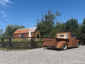 An old truck with 'SOUTHWEST' written on the back, parked in front of a rustic barn. - Rustwood Manor (Malmesbury)
