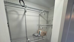 Et garderobrum med metalkasser, en bøjlestang og en lille opbevaringskasse.