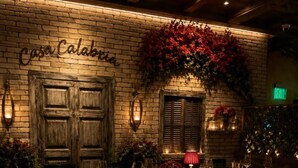 Een restaurant met een bakstenen muur, houten deuren en een gedekte tafel.