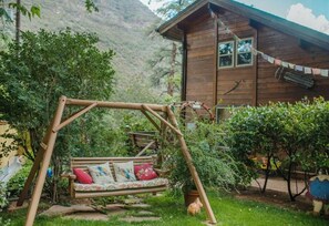 A wooden cabin with a swing set in a lush garden. - Rustic Cabin by Slide Rock - Sycamore (Sedona)