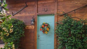 A wooden building with a green door, a wreath, and a lantern. - Rustic Cabin by Slide Rock - Sycamore (Sedona)