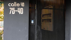 En svart dörr med ett digitalt lås och en skylt med texten ”Calle 48 75-40”.