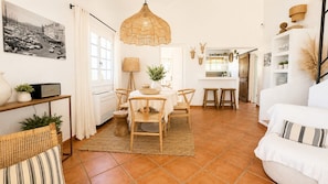 A spacious living area with a dining table, chairs, a hanging light fixture, and a white sofa. - Villa la maison du Sud by Sea view property rental (les issambres)