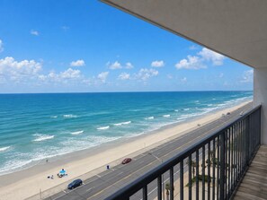 Ein Balkon mit Blick auf Strand und Meer.
