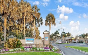 Schild für Ocean Lakes mit einer Straße, Palmen und blauem Himmel.