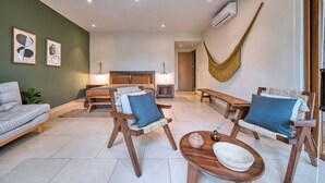 A modern living room with a sofa, two armchairs, a coffee table, and a hammock. - Haixa Resort with Terrace in Punta Mita (Higuera Blanca)