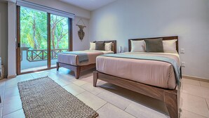 A bedroom with two beds, a large sliding glass door to a balcony, and a woven rug on the floor. - Haixa Resort with Terrace in Punta Mita (Higuera Blanca)