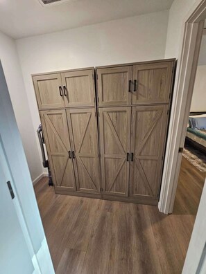 Una habitación con un armario grande, una cama y una puerta que da a otra estancia.