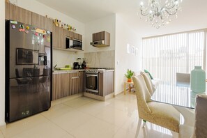 Eine moderne Küche mit Kühlschrank, Backofen, Mikrowelle und Holzschränken.