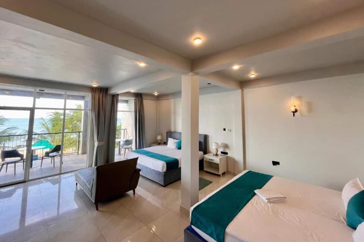 Una habitación de hotel con balcón, cama, escritorio y una silla.