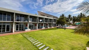 Un bâtiment moderne à plusieurs étages, doté de grandes fenêtres et d’une pelouse bien entretenue.