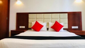 A hotel room with a large bed, two bedside tables, and wall-mounted lighting.