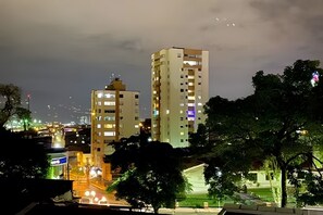 A high-rise building with multiple floors, surrounded by trees and a well-lit street. - Apartamento en la zona más exclusiva de Pereira - by ALPES apartamentos (Pereira)