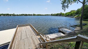 A wooden dock extending into a calm lake with a clear sky.