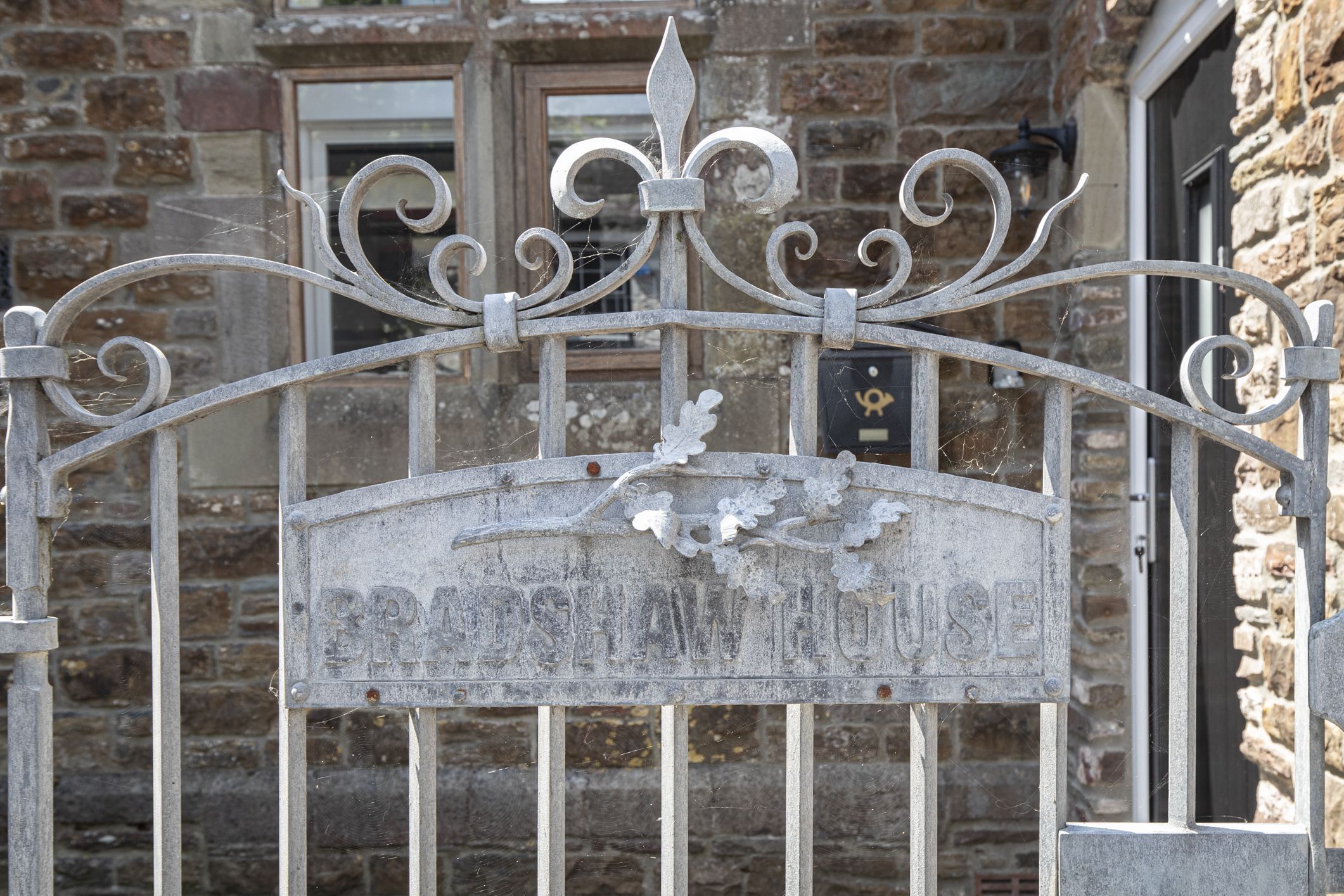 A wrought iron gate with a sign that reads 'BRUNSWICK HOUSE.'