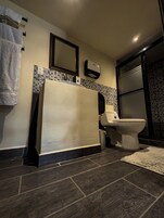 Un baño con bañera, inodoro y secamanos.