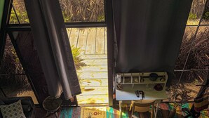 En trappe fører op til et rum med et skilt, der står 'HOME', et lille bord med en lampe og udsigt udad.