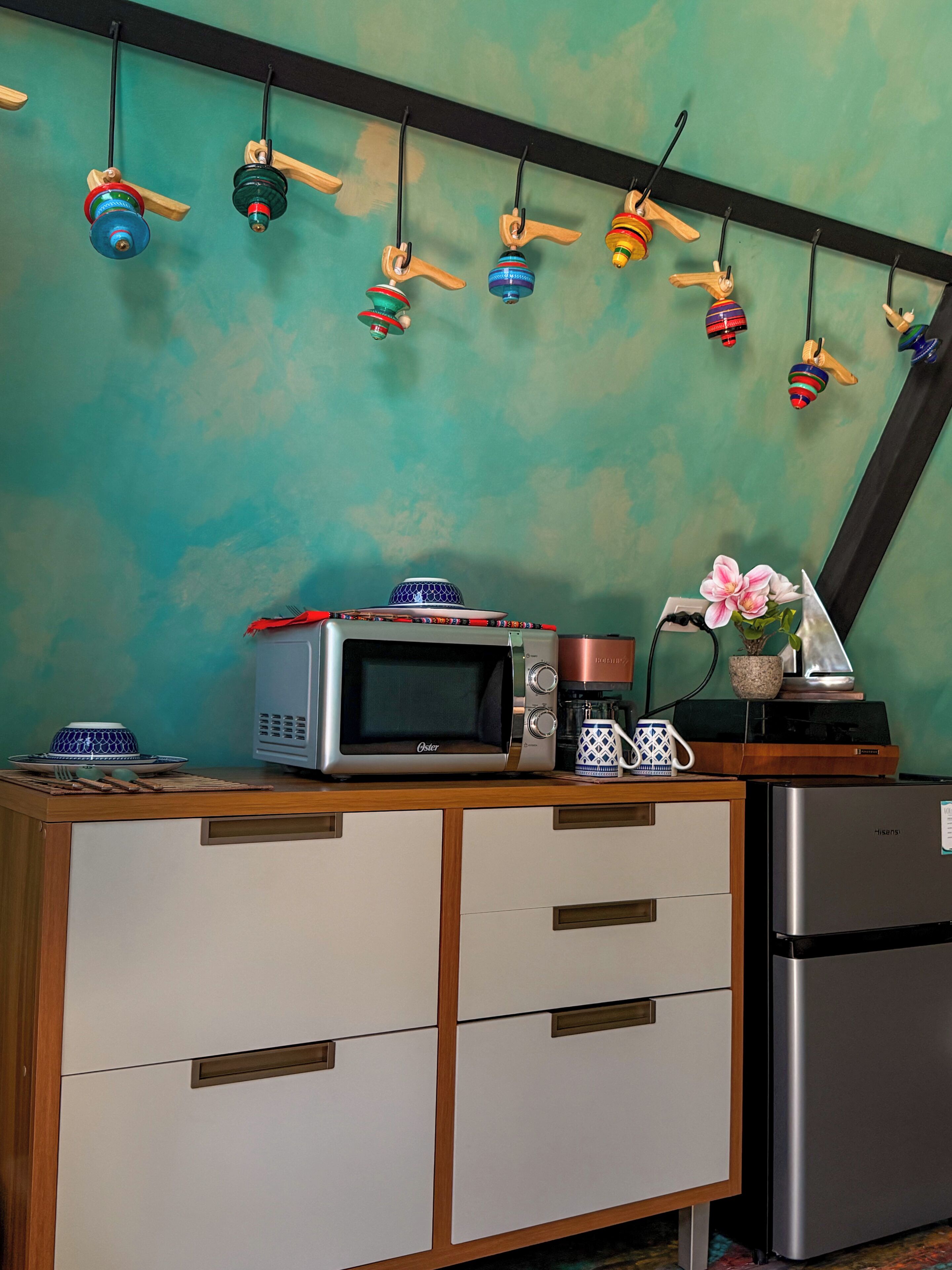 A kitchen with a microwave, coffee maker, and a refrigerator.