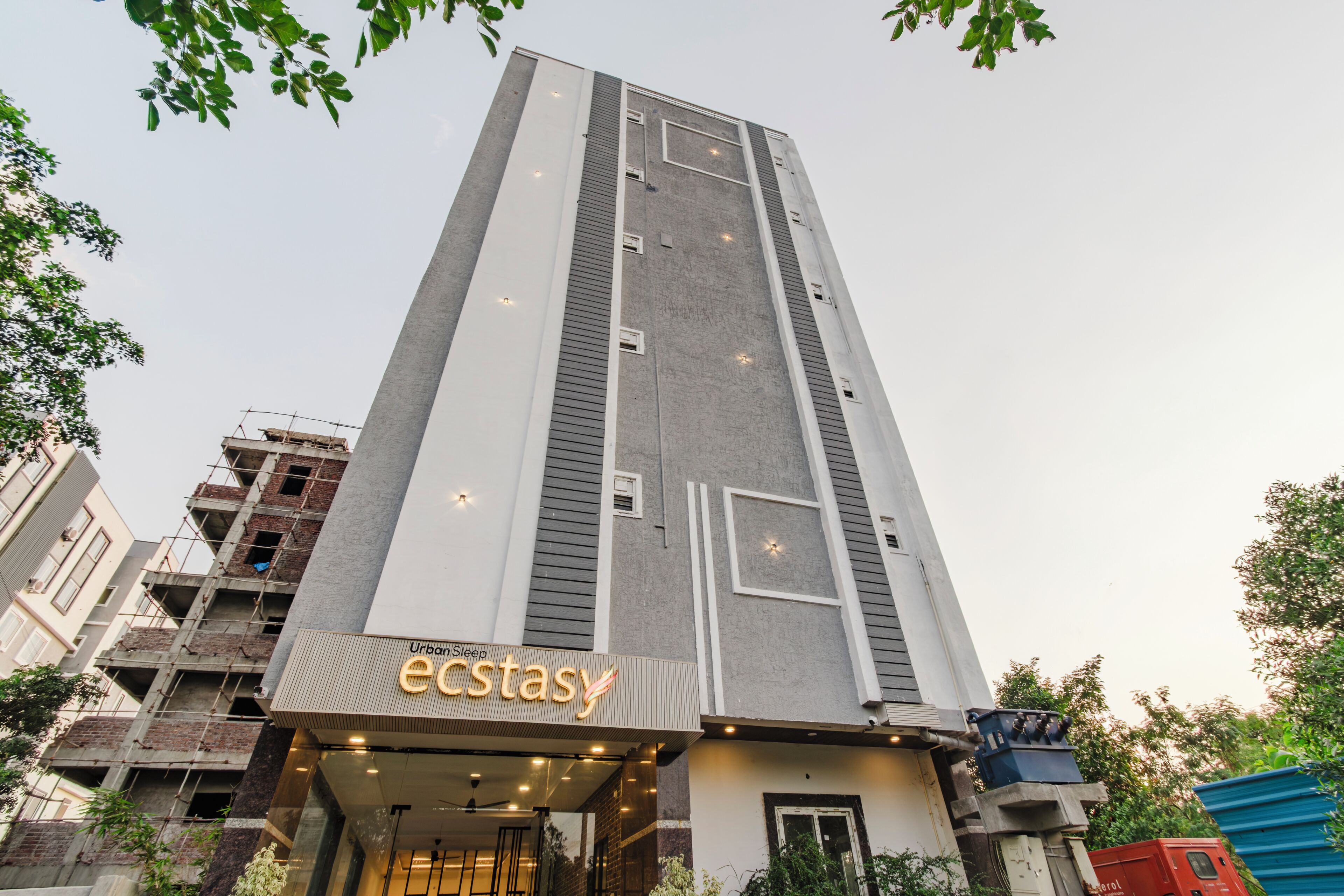 A tall building with a sign for 'Urban Sleep Ecstay' at the ground level.