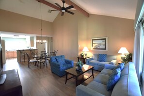 A spacious living room with a dining area, a ceiling fan, and a kitchen in the background. - Island Days at Brigantine, Beach, Pool, Golf (Hilton Head Island)