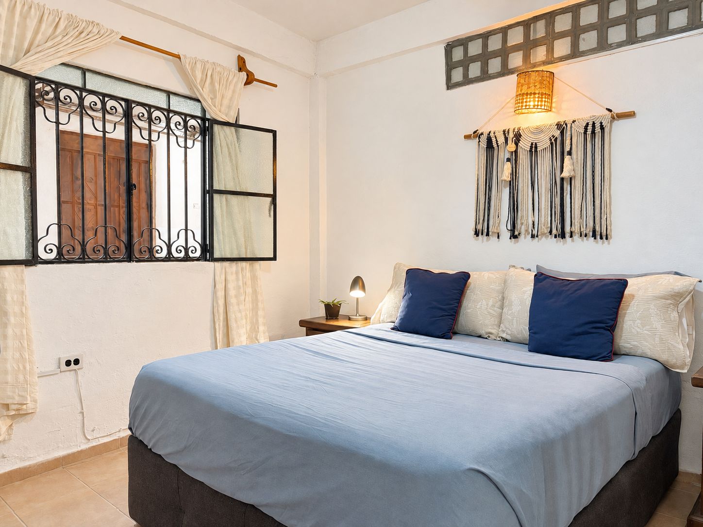 Bright boho bedroom with cozy king bed and charming natural light