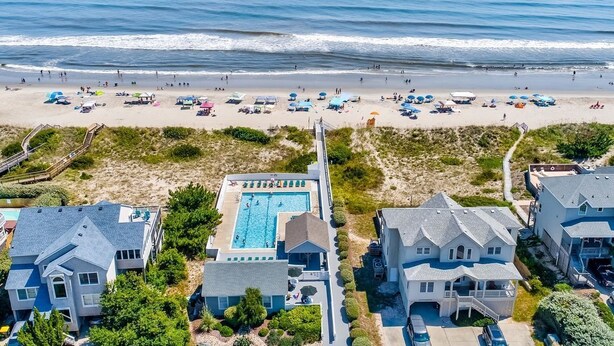 An aerial view of a coastal property with a swimming pool, beachfront, and multiple houses. - Corolla Retreat w/ Views, Hot Tub & Amenities (Corolla)
