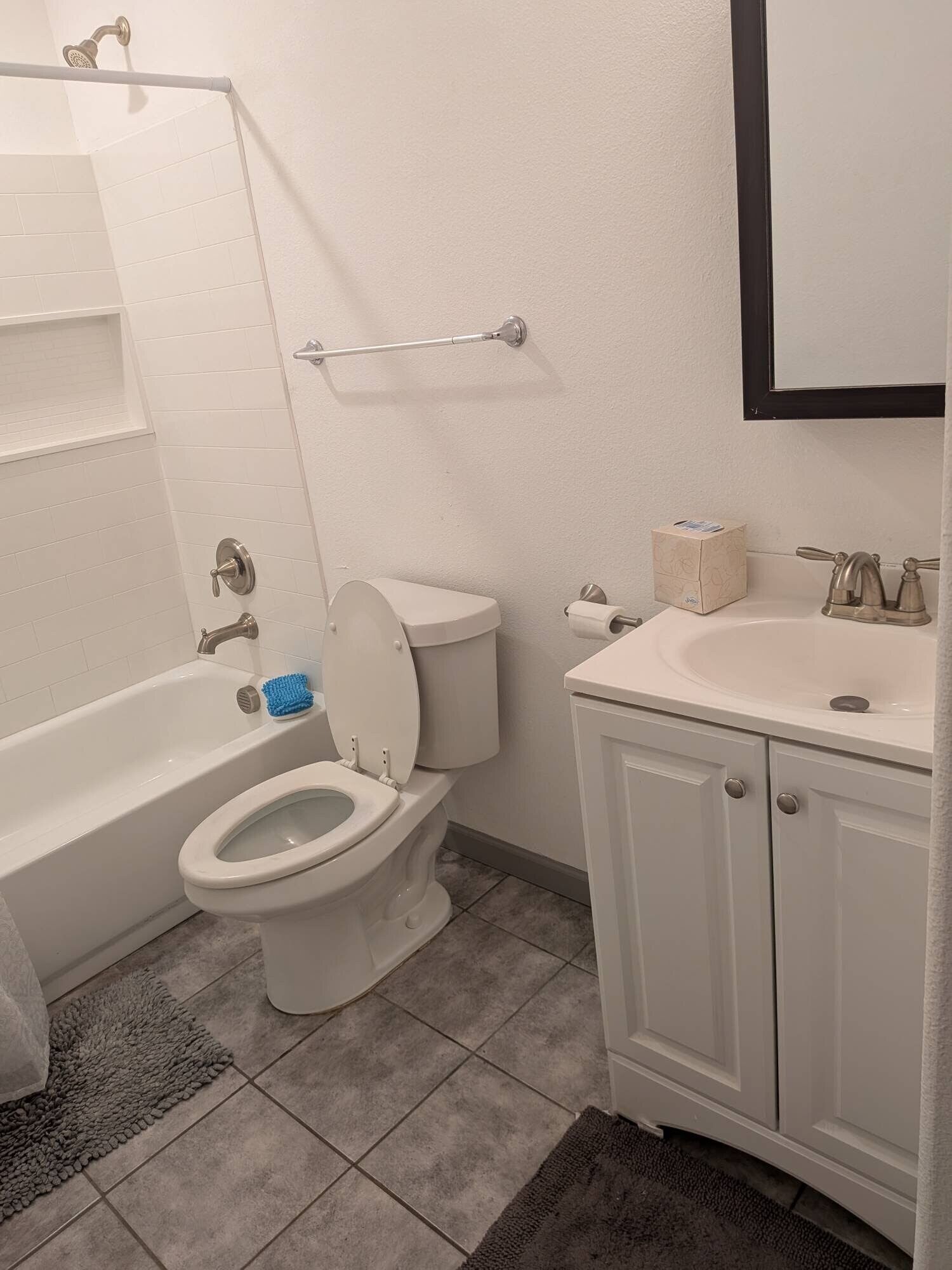 Ein Badezimmer mit Badewanne, Toilette, Waschbecken und Handtuchhalter.