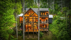 A multi-level cabin with a wooden exterior, large windows, and a balcony. - Family Retreat on Fightingtown Creek • HotTub • FirePit • Games • Creek Access (Blue Ridge)