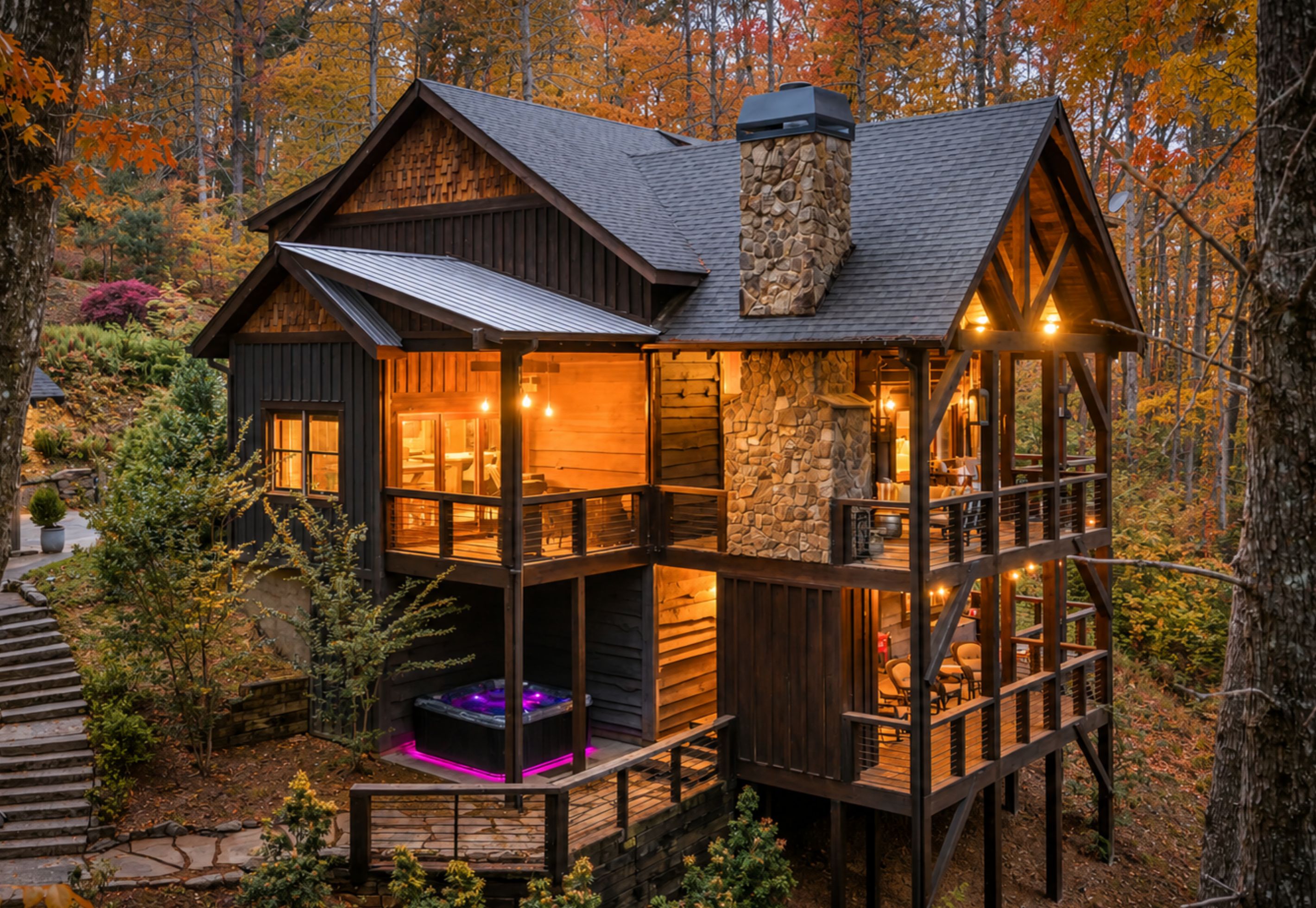 A cabin with a stone fireplace, wooden deck, and a hot tub.