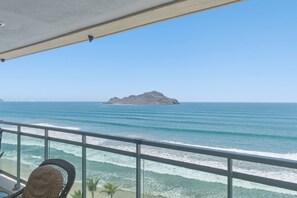 Ein Balkon mit Blick auf das Meer und eine entfernte Insel.