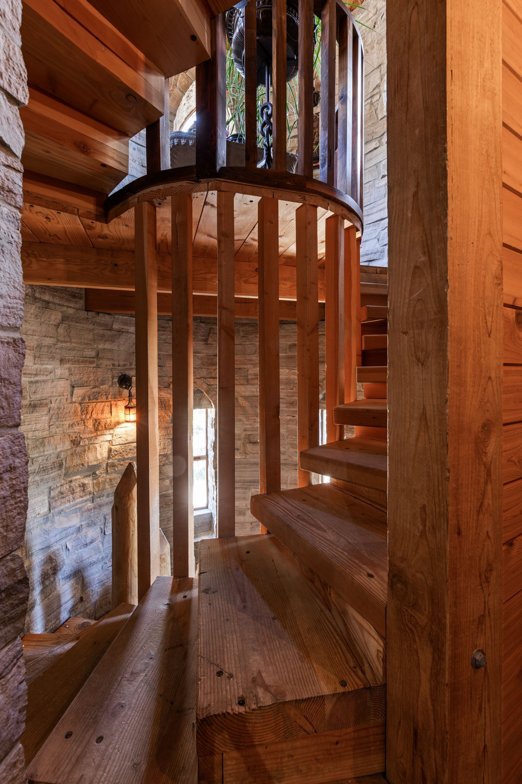 Eine Wendeltreppe aus Holz mit Steinwänden und Holzboden.