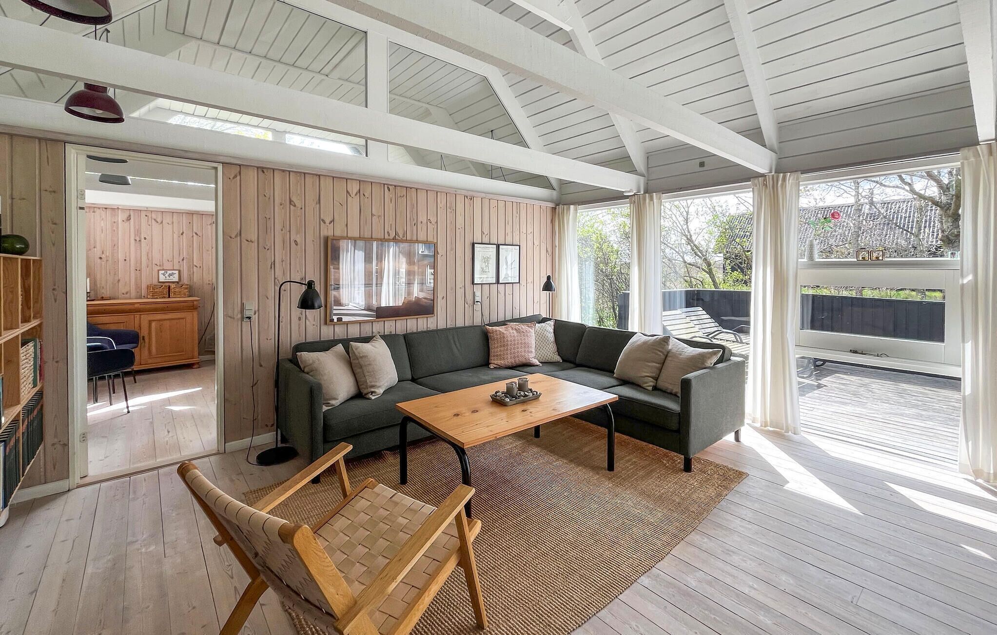 A modern living room with a sofa, coffee table, and a view of the outdoors.