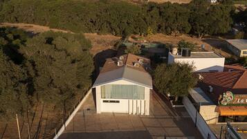 Un quartier résidentiel avec une maison dotée d’un toit en pente, d’une cour clôturée et offrant une vue sur les montagnes lointaines.