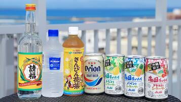 Diversas bebidas sobre uma mesa com vista para o mar.