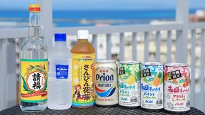 A variety of beverages on a table with a view of the sea.