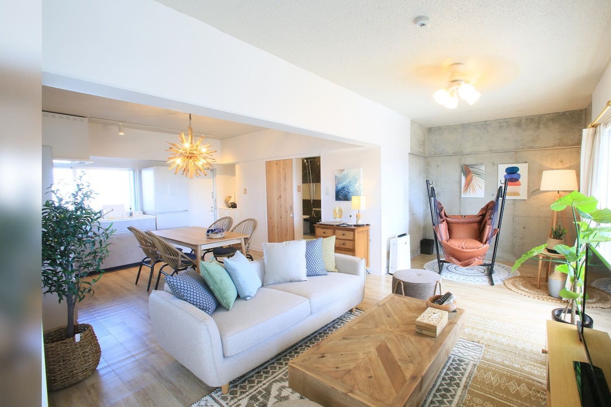 A spacious living room with a sofa, coffee table, and a hanging chair.