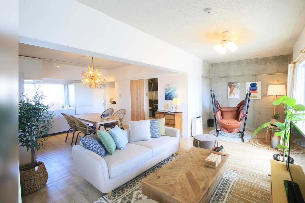 A spacious living room with a sofa, coffee table, and a hanging chair.