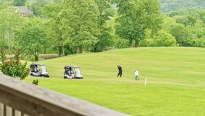 Camp de golf amb un club, un carret de golf i una persona jugant a golf.