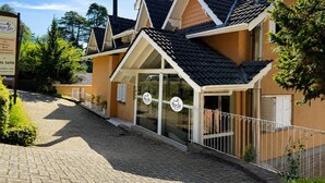 A traditional-style building with a tiled roof, a chimney, and a sign indicating it is a restaurant. - Pousada nosso lar (Gramado)