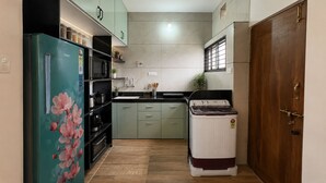 Une cuisine de taille réduite équipée d’un réfrigérateur, d’une cuisinière, d’un évier et de placards.