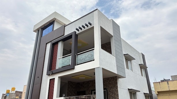 Un immeuble moderne à plusieurs étages, doté d’un toit plat, de grandes fenêtres et d’un balcon.