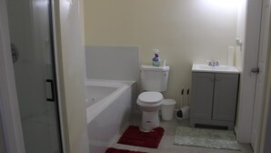 A small bathroom with a toilet, a sink, and a shower. - Cozy 1-bedroom apartment in perfect Covington with AC (Covington)